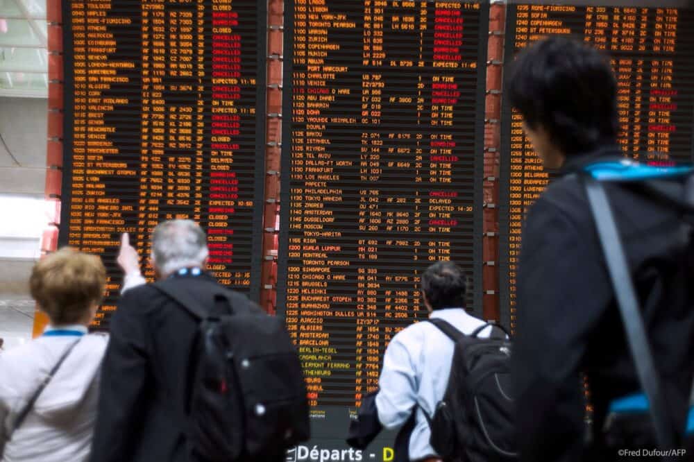 Călătorii privesc tabela cu Plecări cu multe zboruri anulate, la aeroportul internațional Roissy Charles de Gaulle lângă Paris Sursă: PE