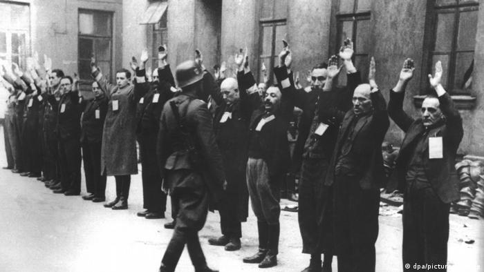 Evrei în ghetoul din Varşovia, cu mâinile ridicate, înainte de a fi duşi la Treblinka